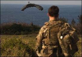 A person in camouflage looking at a seagull flying in the sky
AI-generated content may be incorrect.