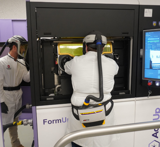 Students at Ohio State University’s Center for Design and Manufacturing Excellence (CDME) operate a metal additive manufacturing machine