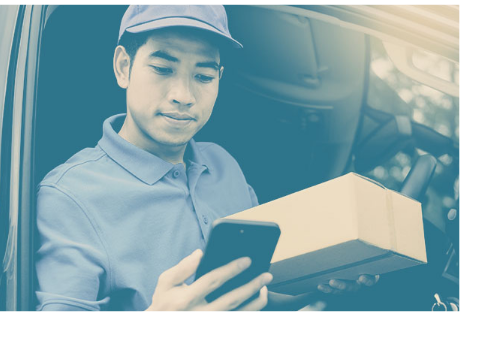 Photo of a delivery man holding a package and checking delivery details on his smartphone